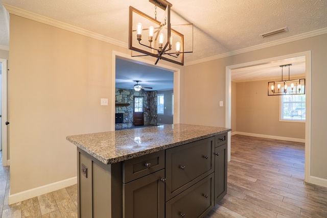 kitchen featuring light stone counters, a healthy amount of sunlight, a textured ceiling, and light hardwood / wood-style floors