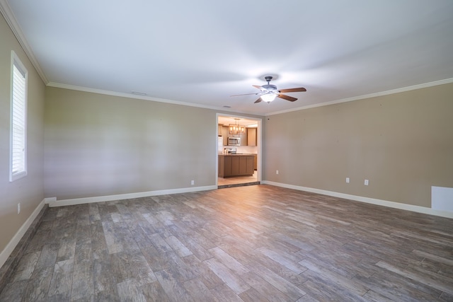 spare room featuring hardwood / wood-style floors, ceiling fan with notable chandelier, and ornamental molding