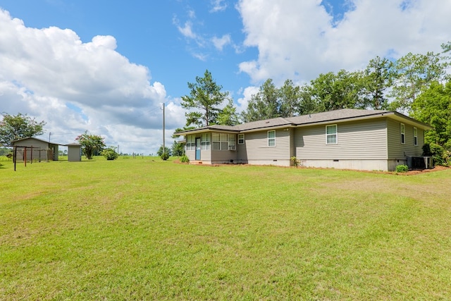 back of property with a lawn and central air condition unit