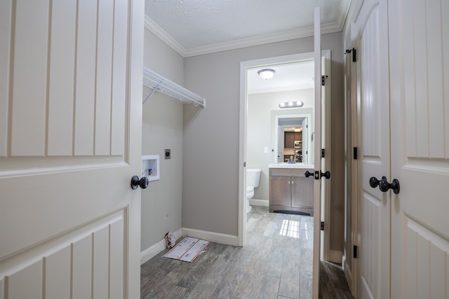 laundry area featuring sink, dark wood-type flooring, hookup for an electric dryer, crown molding, and a textured ceiling