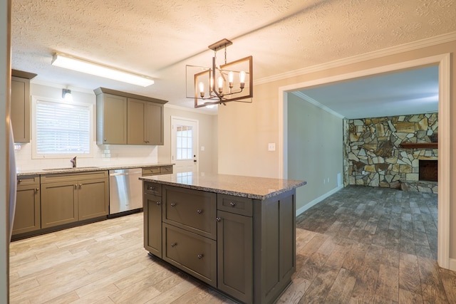 kitchen featuring light wood-type flooring, decorative light fixtures, dishwasher, a kitchen island, and plenty of natural light