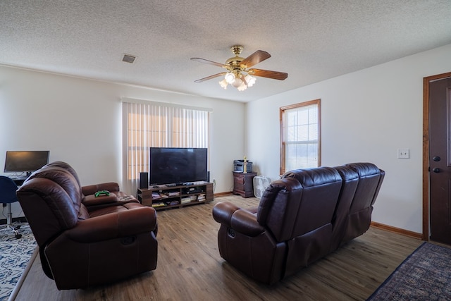 living room featuring a textured ceiling, ceiling fan, and wood-type flooring