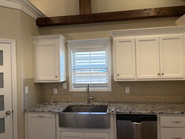 kitchen featuring white cabinetry, stainless steel dishwasher, and sink