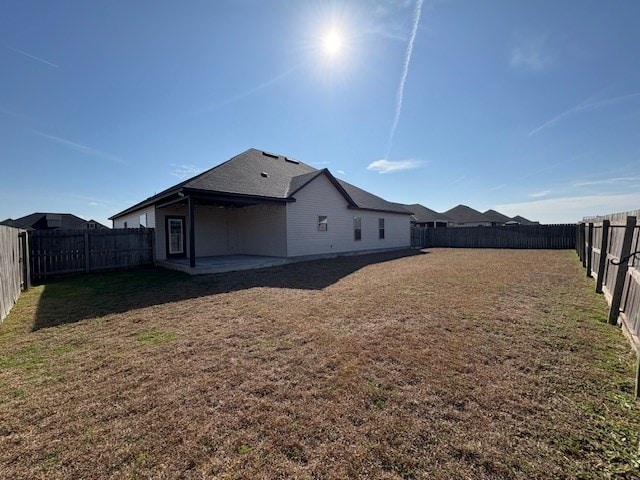 rear view of house with a patio and a yard