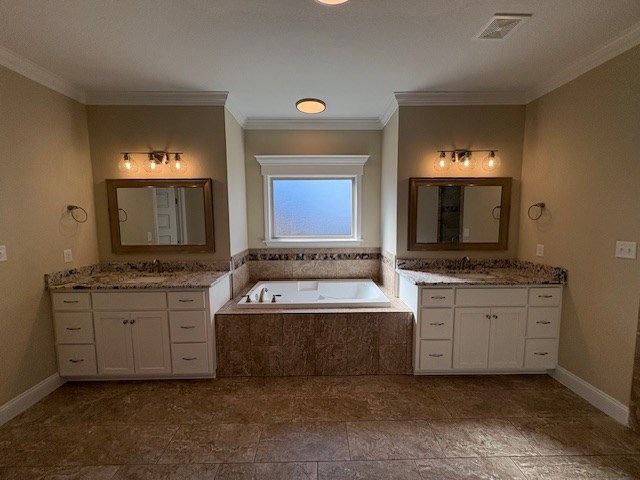 bathroom with a relaxing tiled tub, vanity, and ornamental molding