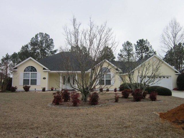 single story home with a garage and a front lawn