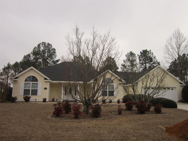 single story home with a garage and a front lawn