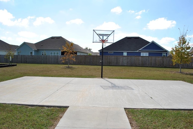 view of sport court featuring a lawn and a fenced backyard