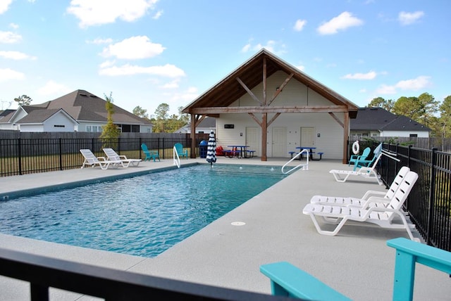 view of swimming pool featuring fence, an outbuilding, a fenced in pool, and a patio