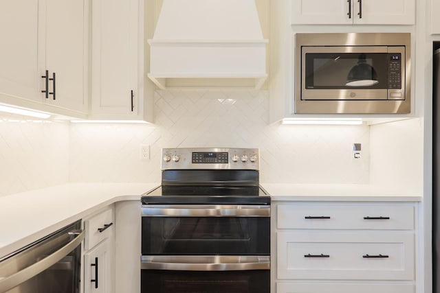 kitchen featuring custom range hood, appliances with stainless steel finishes, light countertops, white cabinetry, and backsplash