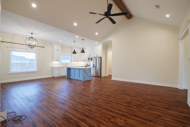 unfurnished living room with baseboards, dark wood-style floors, beamed ceiling, a sink, and ceiling fan with notable chandelier