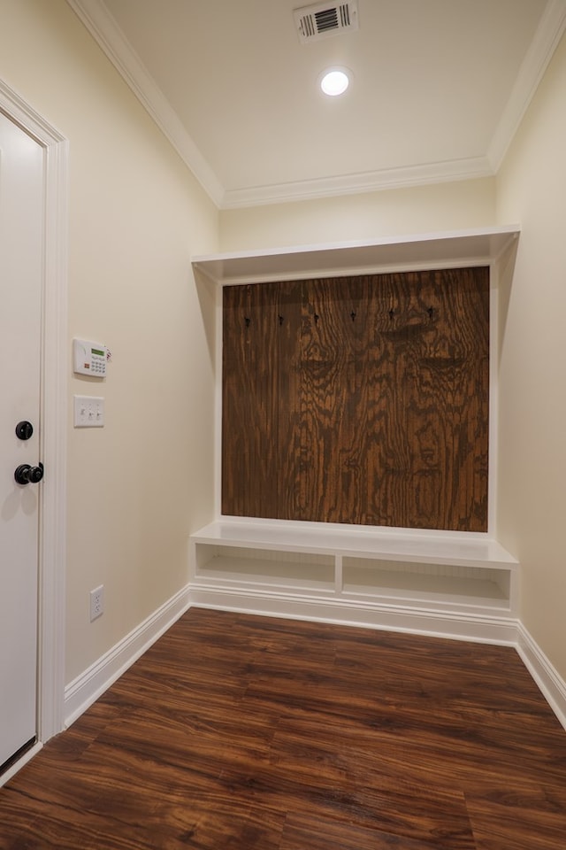 interior details featuring ornamental molding, visible vents, baseboards, and wood finished floors