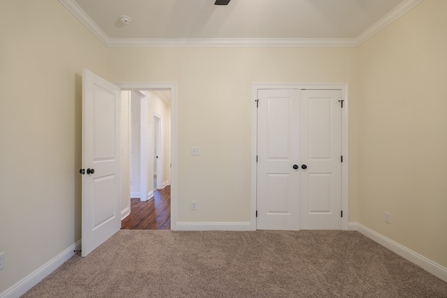 unfurnished bedroom with baseboards, carpet floors, a closet, and crown molding