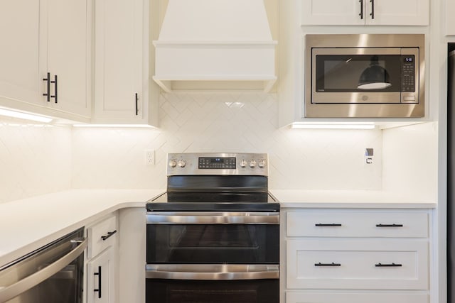 kitchen with white cabinetry, stainless steel appliances, and light countertops