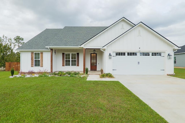 view of front of home featuring an attached garage, a shingled roof, driveway, board and batten siding, and a front yard