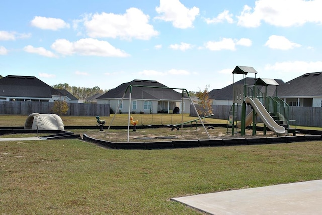 community playground featuring a yard, fence, and a residential view