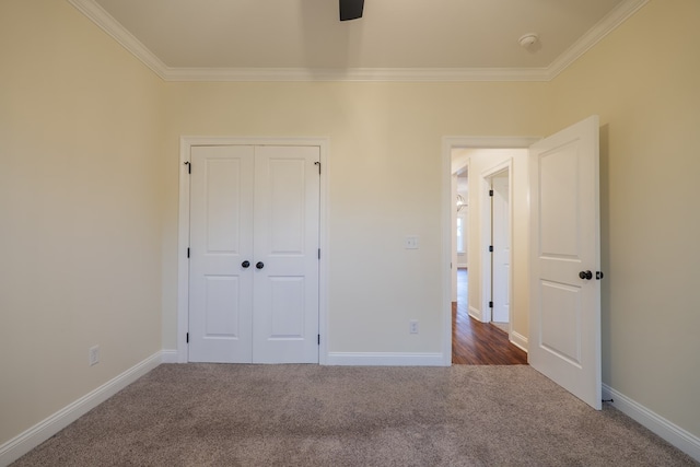 unfurnished bedroom with crown molding, baseboards, and carpet flooring