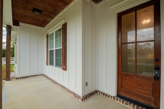 view of exterior entry featuring covered porch and board and batten siding