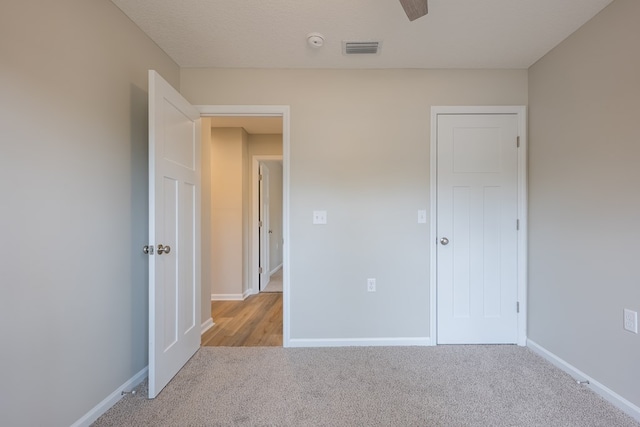 unfurnished bedroom featuring visible vents, light carpet, and baseboards