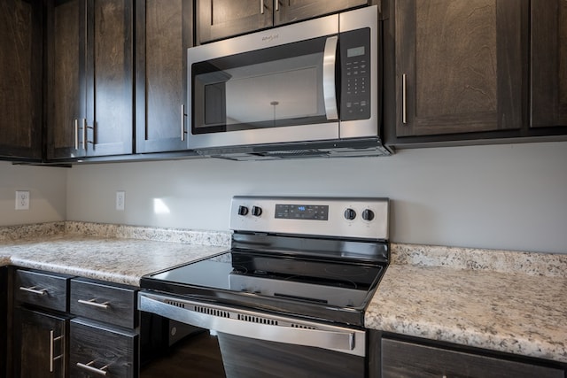 kitchen featuring stainless steel appliances, dark brown cabinets, and light countertops