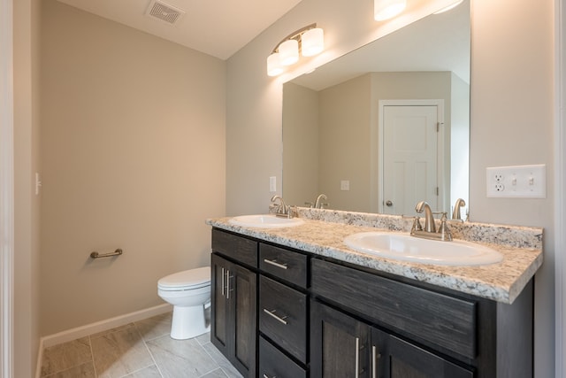 full bathroom featuring visible vents, a sink, toilet, and double vanity