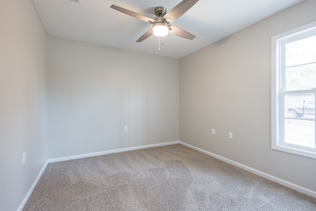 carpeted empty room featuring a textured ceiling, a ceiling fan, and baseboards