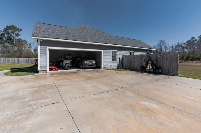 view of home's exterior featuring a garage, fence, driveway, and roof with shingles