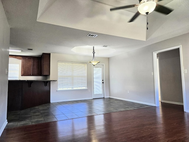 unfurnished living room with dark hardwood / wood-style floors and ceiling fan