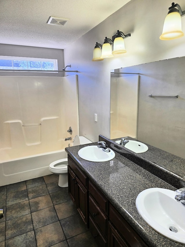 full bathroom with shower / tub combination, vanity, a textured ceiling, and toilet