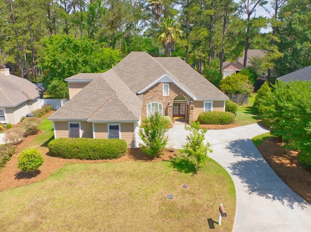 view of front facade featuring concrete driveway, roof with shingles, french doors, and a front yard