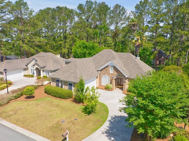 view of front of property with a garage, a shingled roof, driveway, and stone siding
