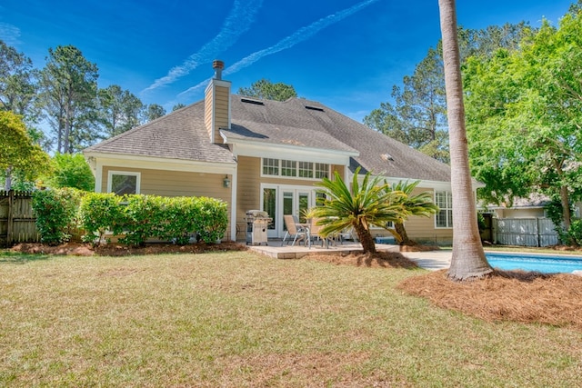 back of house with a lawn, fence, french doors, and a chimney
