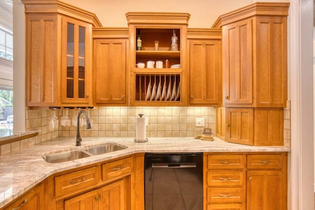kitchen featuring backsplash, light stone countertops, a sink, glass insert cabinets, and black dishwasher