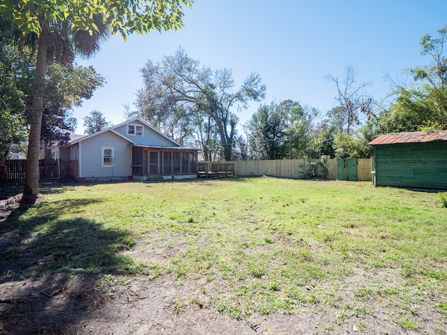 view of yard featuring a sunroom and a fenced backyard