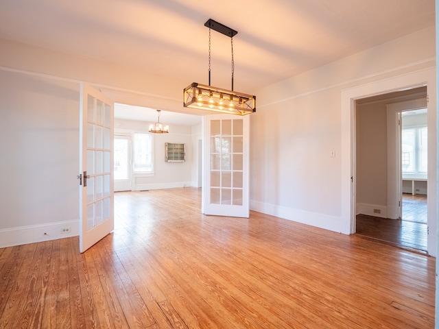 empty room with french doors, baseboards, and wood finished floors