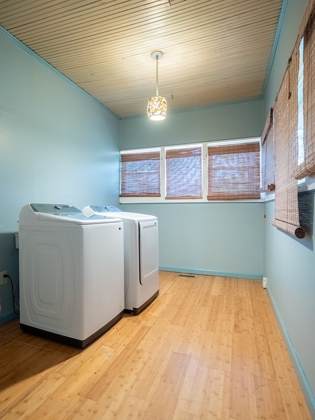 washroom featuring light wood finished floors, washing machine and dryer, wood ceiling, laundry area, and baseboards