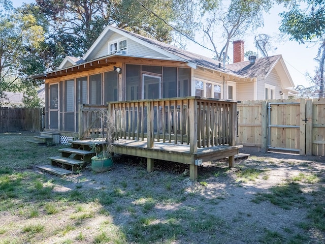 back of property featuring a gate, fence, and a chimney