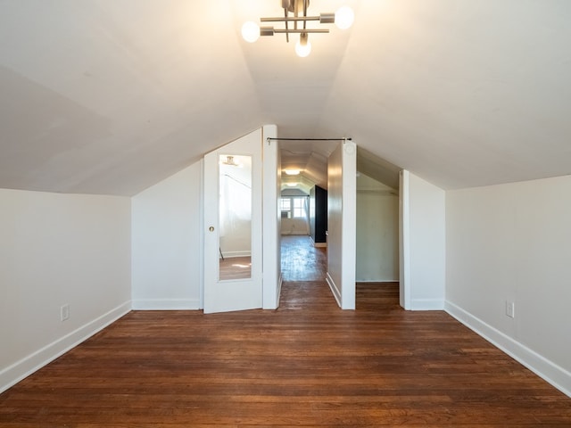 bonus room featuring dark wood-style floors, vaulted ceiling, and baseboards