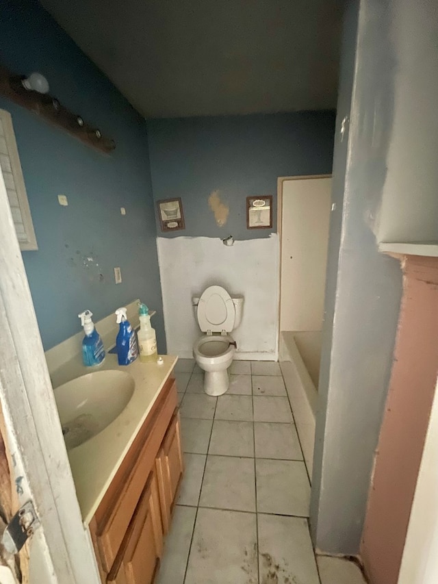 bathroom featuring tile patterned floors, vanity, toilet, and a tub