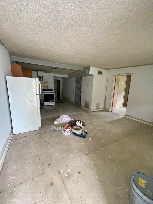 unfurnished living room featuring visible vents and a textured ceiling