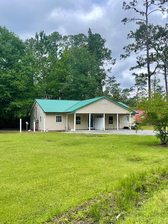 view of front of property featuring metal roof, a porch, and a front lawn