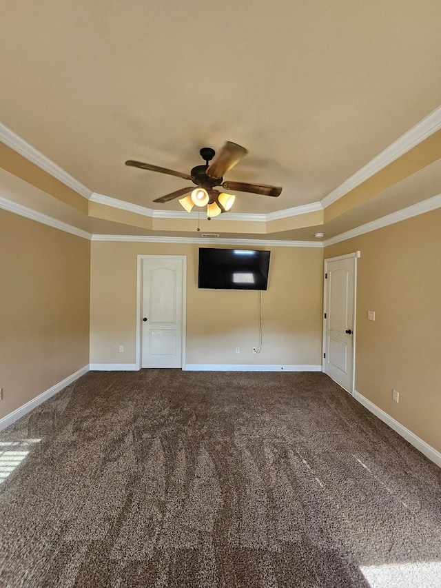 carpeted empty room with a tray ceiling, crown molding, and ceiling fan