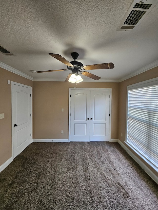 unfurnished bedroom featuring carpet, a closet, ceiling fan, and ornamental molding