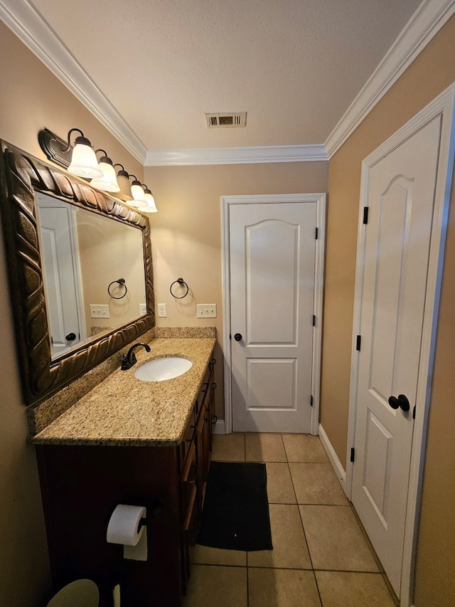 bathroom featuring tile patterned floors, crown molding, and vanity