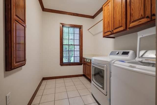 4849 Oak Arbor Dr, Valdosta, GA 31602 - laundry area featuring washing machine and clothes dryer, ornamental molding, cabinet space, and light tile patterned floors