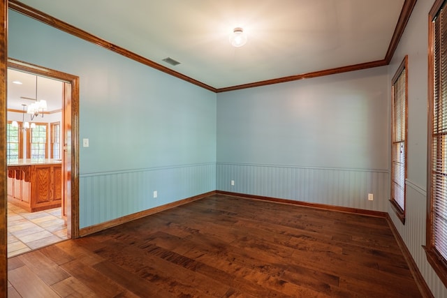 4849 Oak Arbor Dr, Valdosta, GA 31602 - unfurnished room featuring wood-type flooring, a chandelier, ornamental molding, and wainscoting