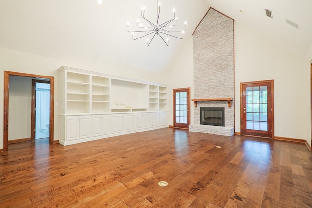4849 Oak Arbor Dr, Valdosta, GA 31602 - unfurnished living room with a chandelier, high vaulted ceiling, plenty of natural light, a brick fireplace, and built in features