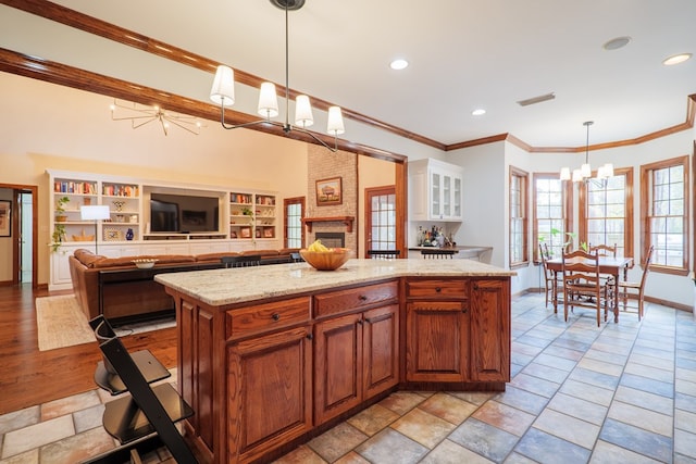 kitchen with ornamental molding, white cabinets, a kitchen island, decorative light fixtures, and a chandelier