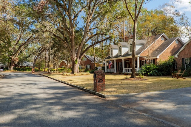 cape cod-style house with a porch and a front yard