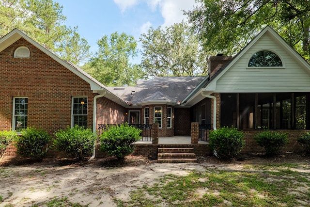 4849 Oak Arbor Dr, Valdosta, GA 31602 - view of front facade featuring a chimney, brick siding, and a sunroom